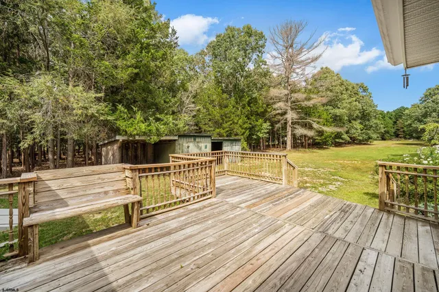 a view of a balcony with wooden floor and fence