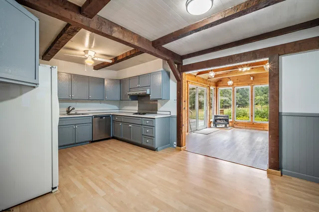 a kitchen with stainless steel appliances granite countertop a sink cabinets and a large window