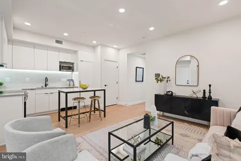 a living room with furniture a dining table and kitchen view