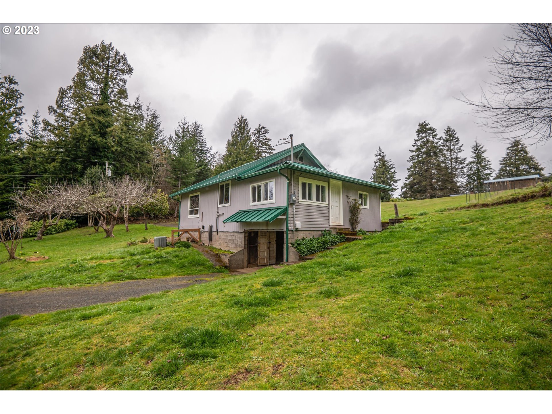63657 Olive Barber Road Coos Bay, OR 97420 - Photo 24 of 34 a view of a house with a big yard and sitting area