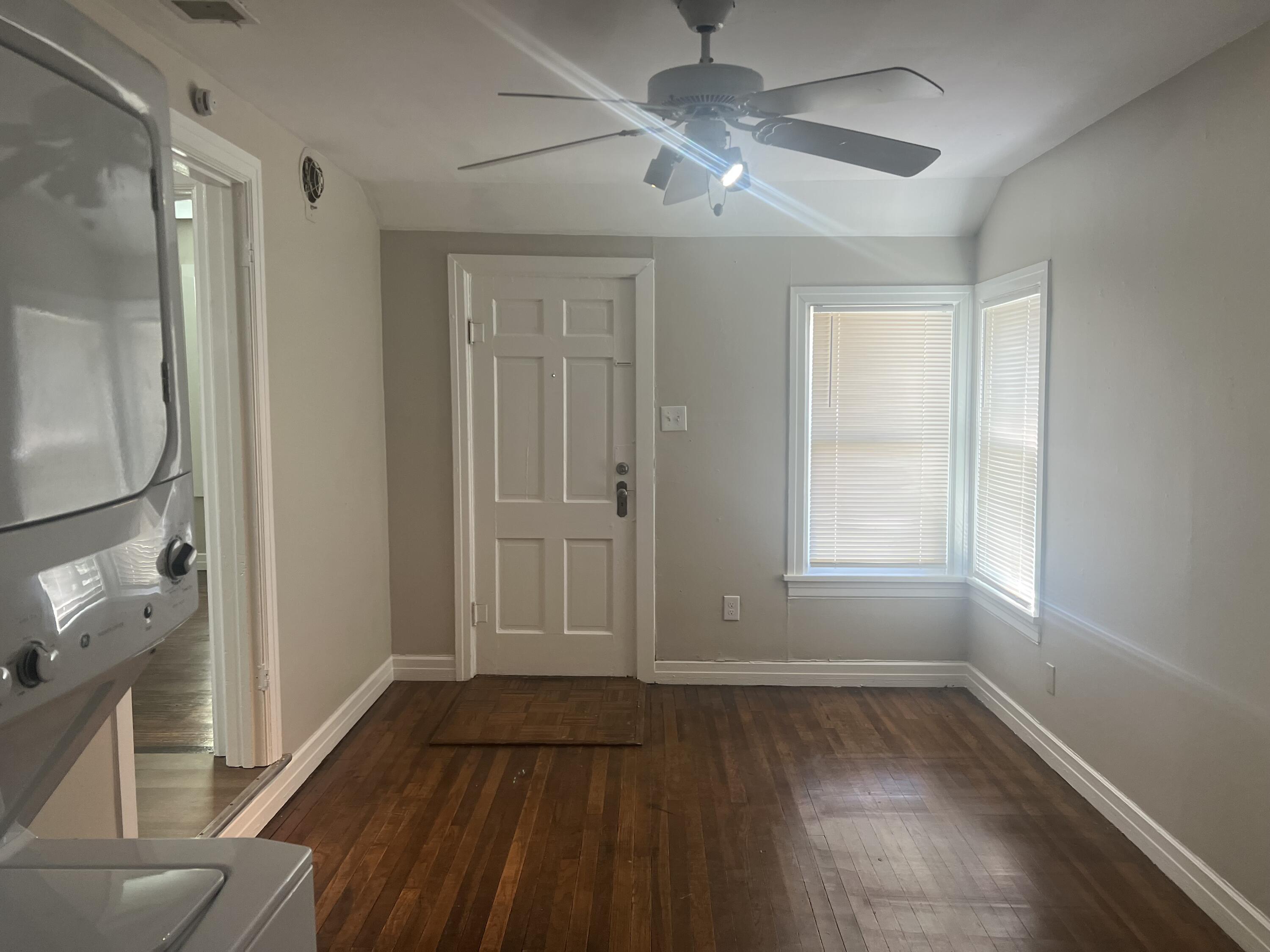 2202 28th Street, Unit B Lubbock, TX 79411 - Photo 4 of 17 wooden floor in an empty room with a window