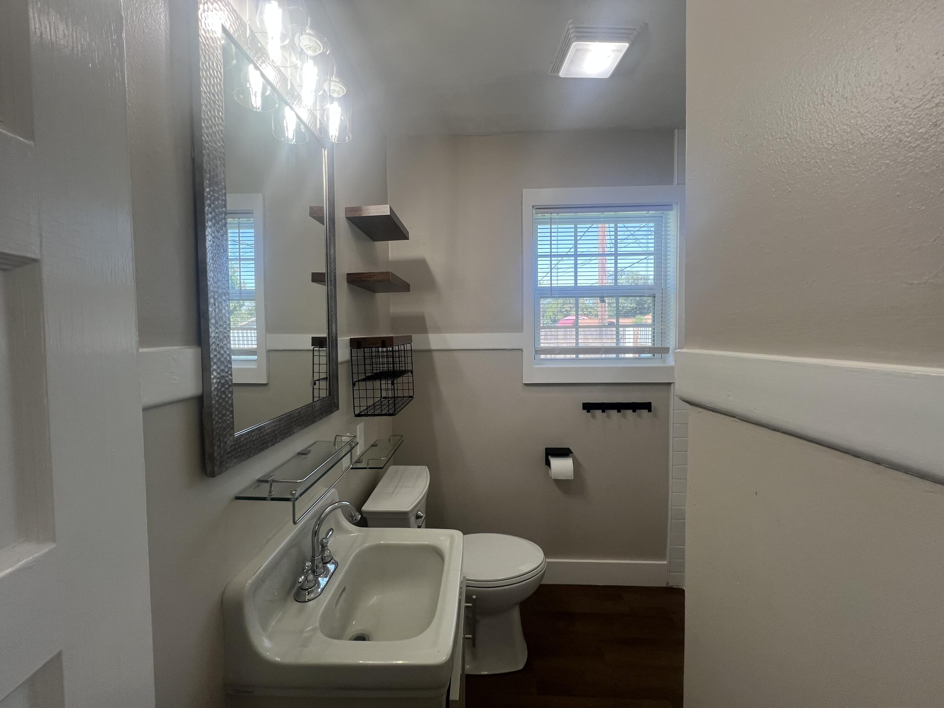 2202 28th Street, Unit B Lubbock, TX 79411 - Photo 5 of 17 a bathroom with a sink a toilet and shower