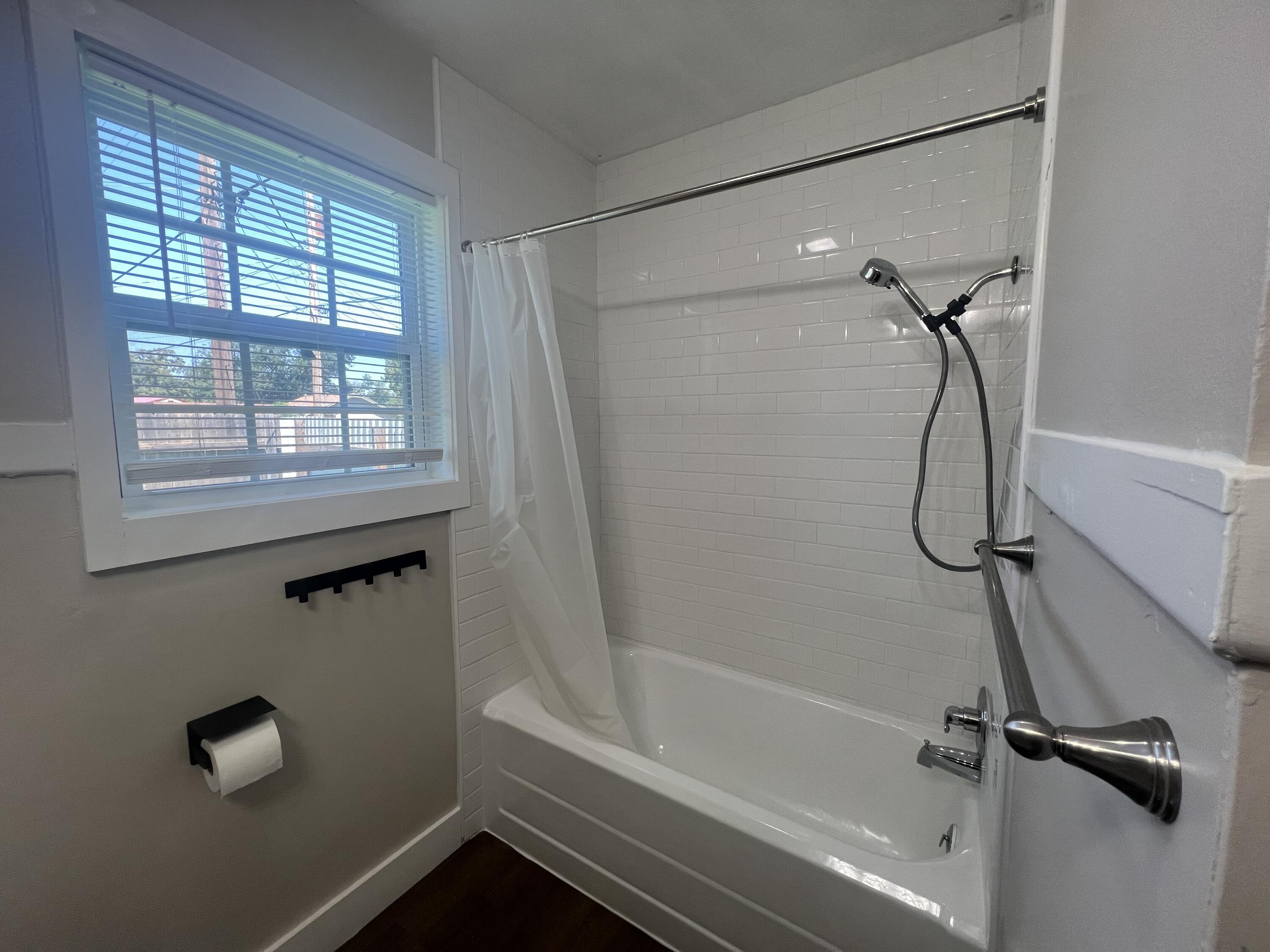 2202 28th Street, Unit B Lubbock, TX 79411 - Photo 6 of 17 a bathroom with a bath tub with a shower