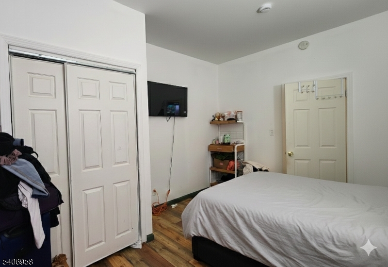 239 South 8th Street Newark, NJ 07103 - Photo 14 of 26 a bedroom with a bed and a flat screen tv