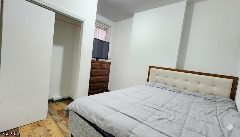 239 South 8th Street Newark, NJ 07103 - Photo 15 of 26 a bedroom with a bed and a flat screen tv