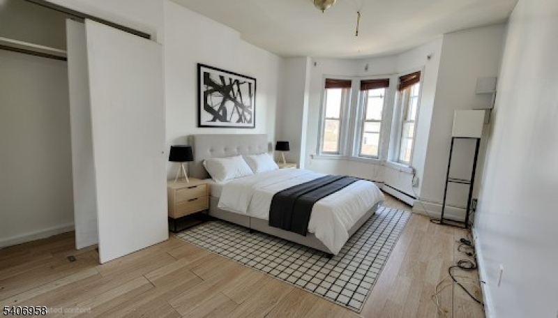 239 South 8th Street Newark, NJ 07103 - Photo 6 of 26 a bedroom with a large bed and a window