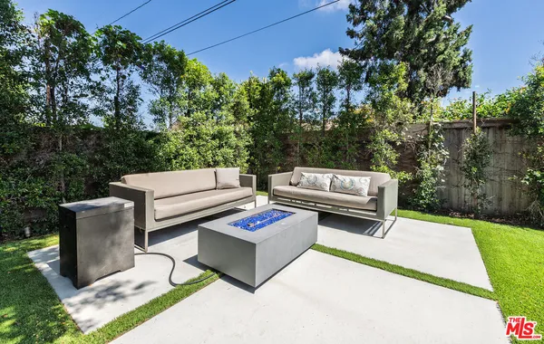 a backyard of a house with barbeque oven and outdoor seating