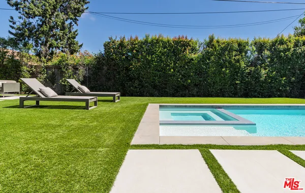 a view of a swimming pool with a bench and trees