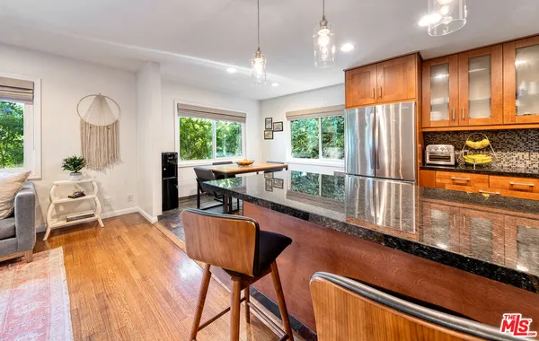 a large kitchen with kitchen island granite countertop a sink a counter space and stainless steel appliances