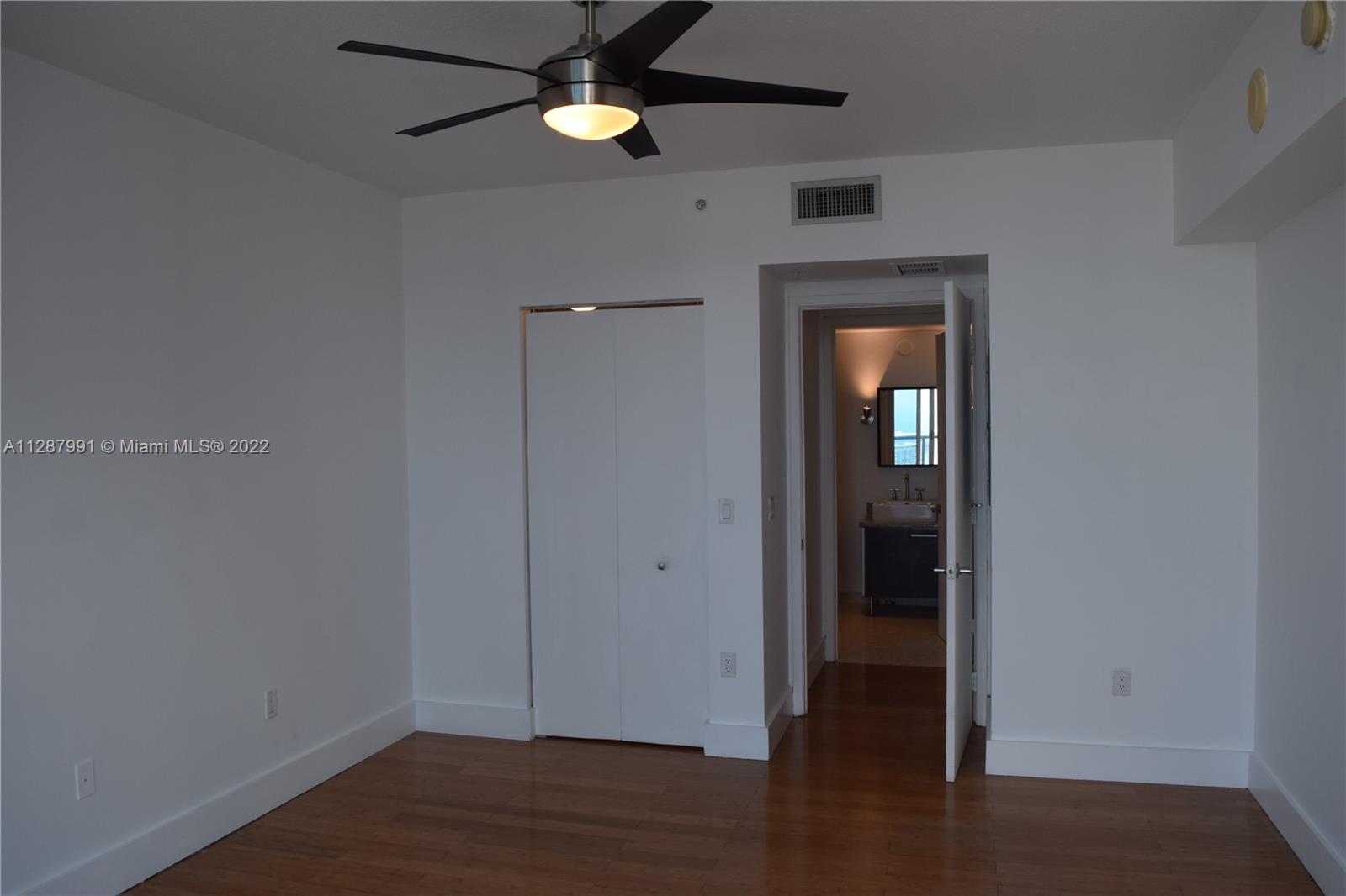 185 Southwest 7th Street, Unit 4014 Miami, FL 33130 - Photo 11 of 21 an empty room with wooden floor and closet