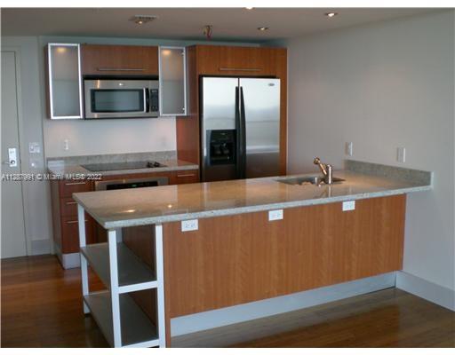 185 Southwest 7th Street, Unit 4014 Miami, FL 33130 - Photo 13 of 21 a room with granite countertop a sink a microwave and cabinets