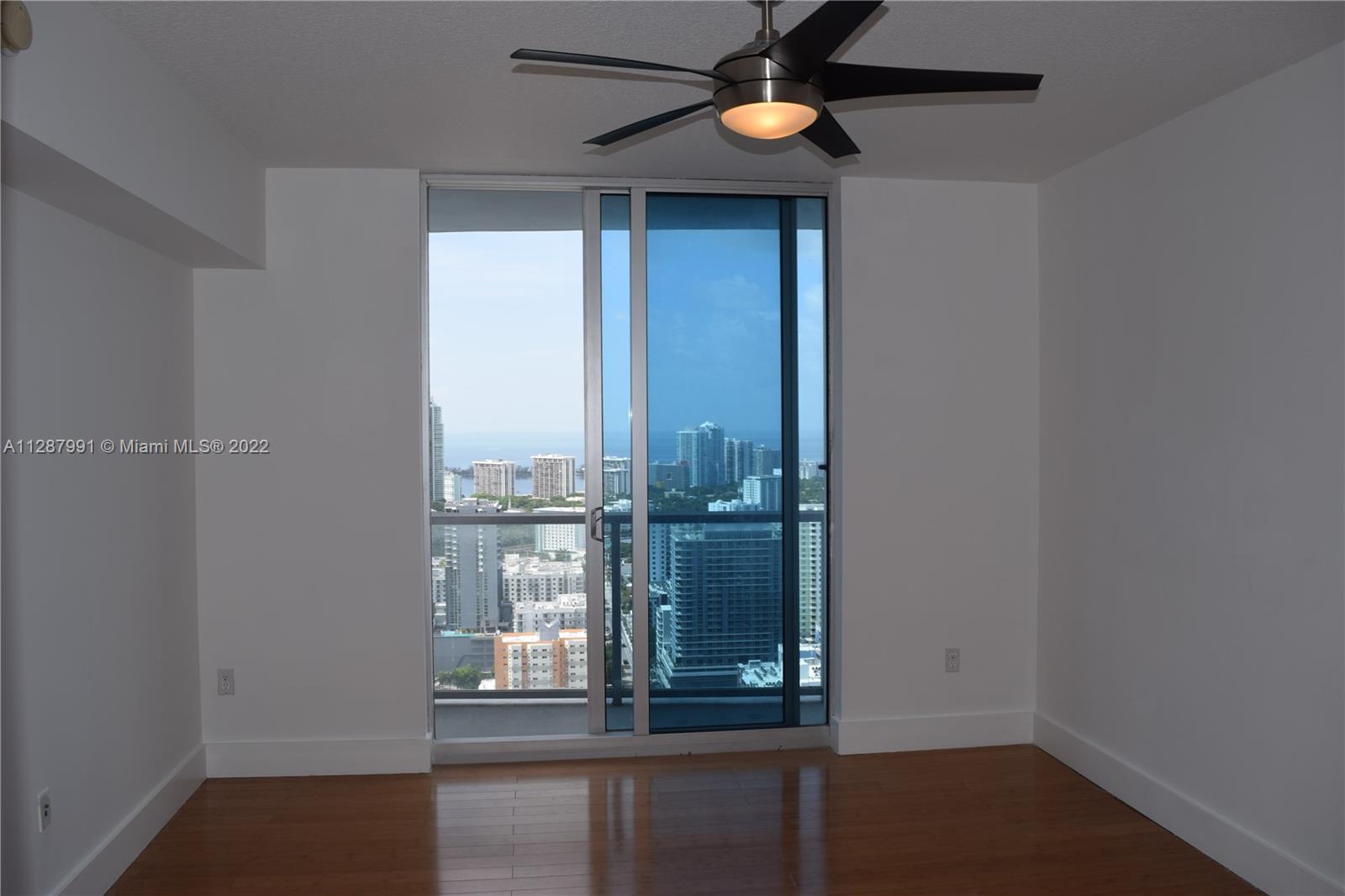 185 Southwest 7th Street, Unit 4014 Miami, FL 33130 - Photo 10 of 21 an empty room with wooden floor and windows