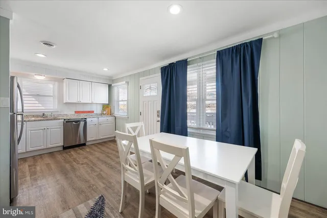 a kitchen with a table chairs refrigerator a sink dishwasher and cabinets