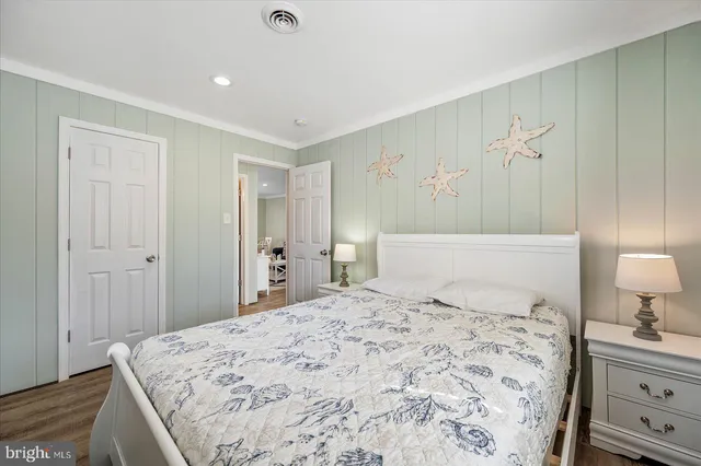 a bedroom with a bed and a lamp on dresser