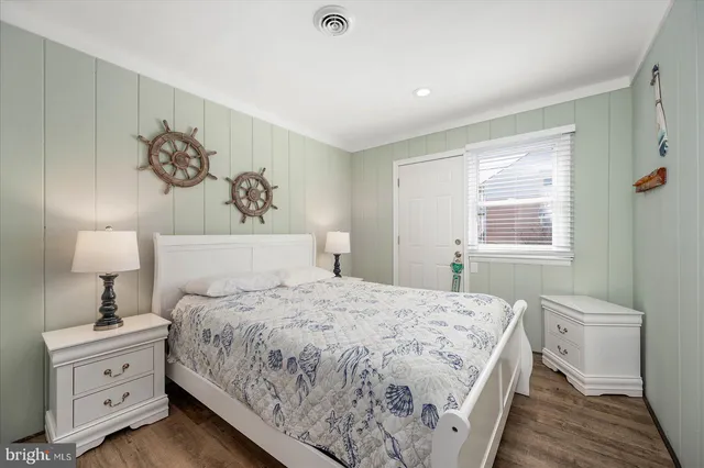 a bedroom with a bed and a lamp on dresser