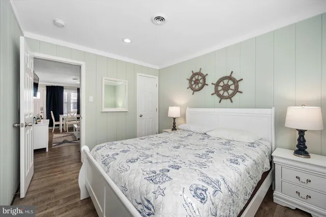 a spacious bedroom with a bed and a lamp on table