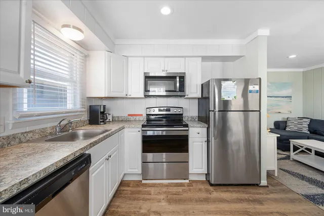 a kitchen with a refrigerator sink and stainless steel appliances