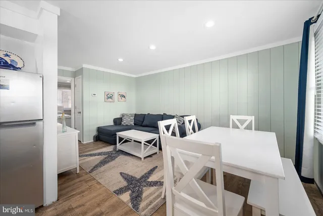 a living room with furniture and a refrigerator