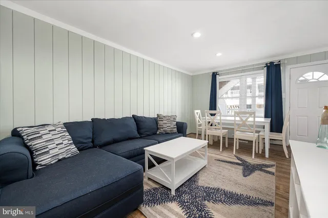 a living room with furniture wooden floor and a window