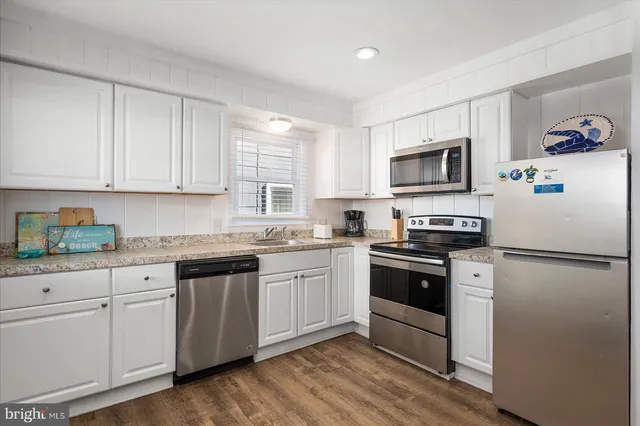 a kitchen with granite countertop white cabinets and white appliances
