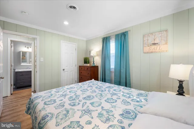 a bedroom with a bed and a lamp on dresser