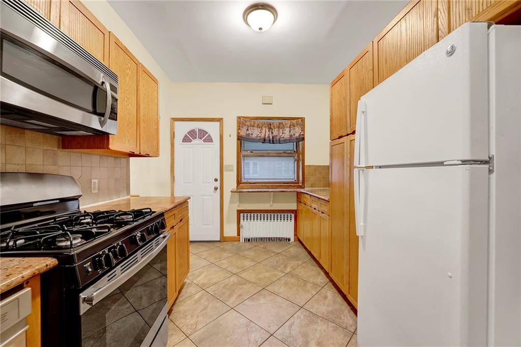 2602 Avenue T Brooklyn, NY 11229 - Photo 6 of 27 a kitchen with a refrigerator and a stove