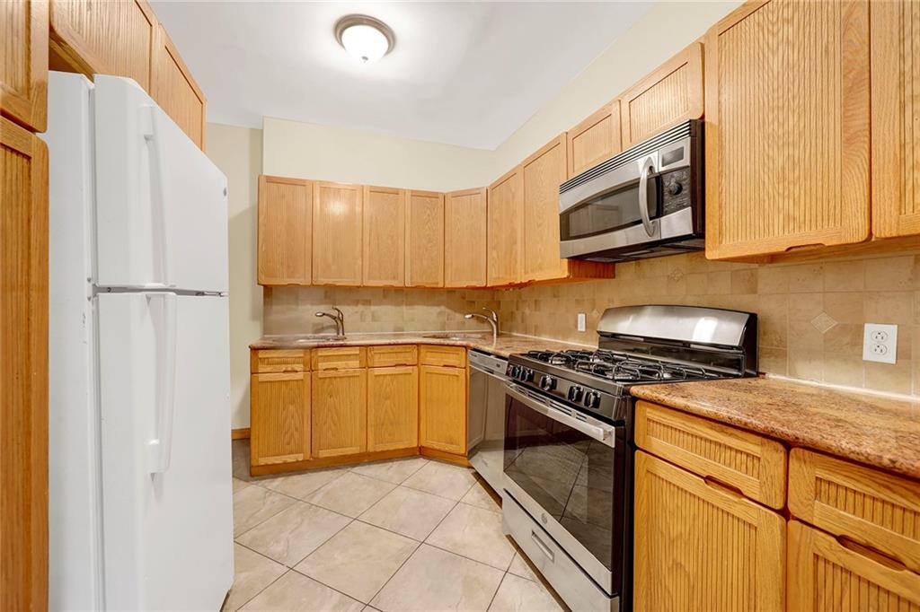 2602 Avenue T Brooklyn, NY 11229 - Photo 8 of 27 a kitchen with stainless steel appliances granite countertop a refrigerator a stove top oven a sink and dishwasher
