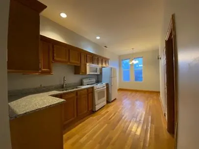 a large kitchen with stainless steel appliances granite countertop a sink and cabinets