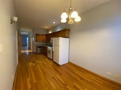 a view of a kitchen with a sink refrigerator and wooden floor
