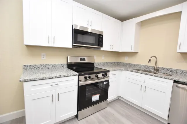 a kitchen with a refrigerator and white cabinets