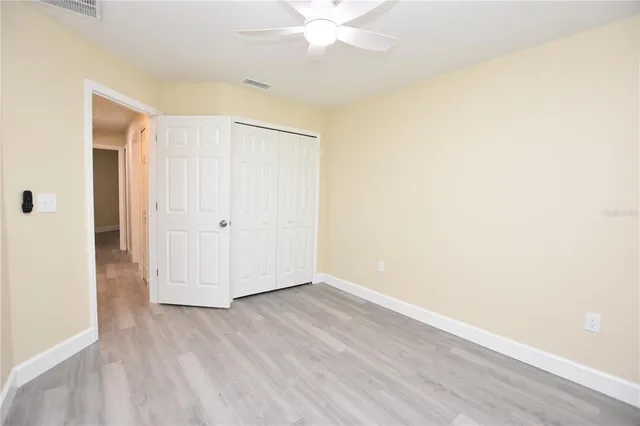 a bedroom with a bed a couch and a potted plant