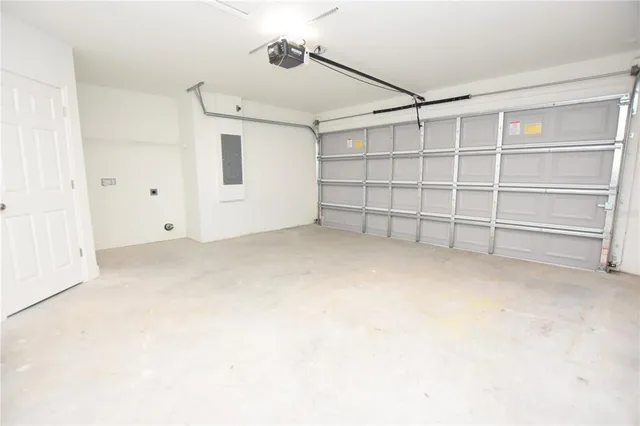 a view of an empty room with wooden floor and a ceiling fan