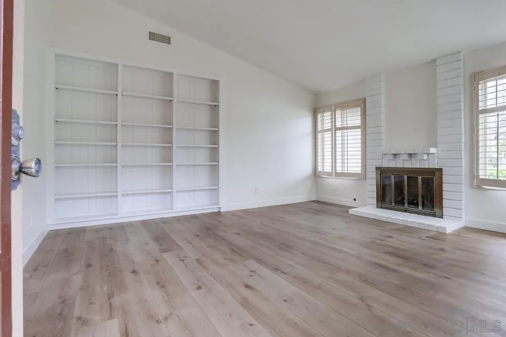 384 Compass Road Oceanside, CA 92054 - Photo 4 of 34 an empty room with a fireplace and window