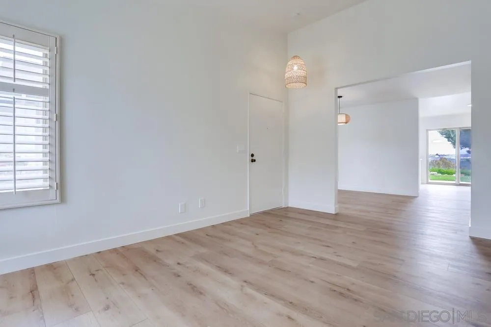 384 Compass Road Oceanside, CA 92054 - Photo 7 of 34 an empty room with wooden floor and windows