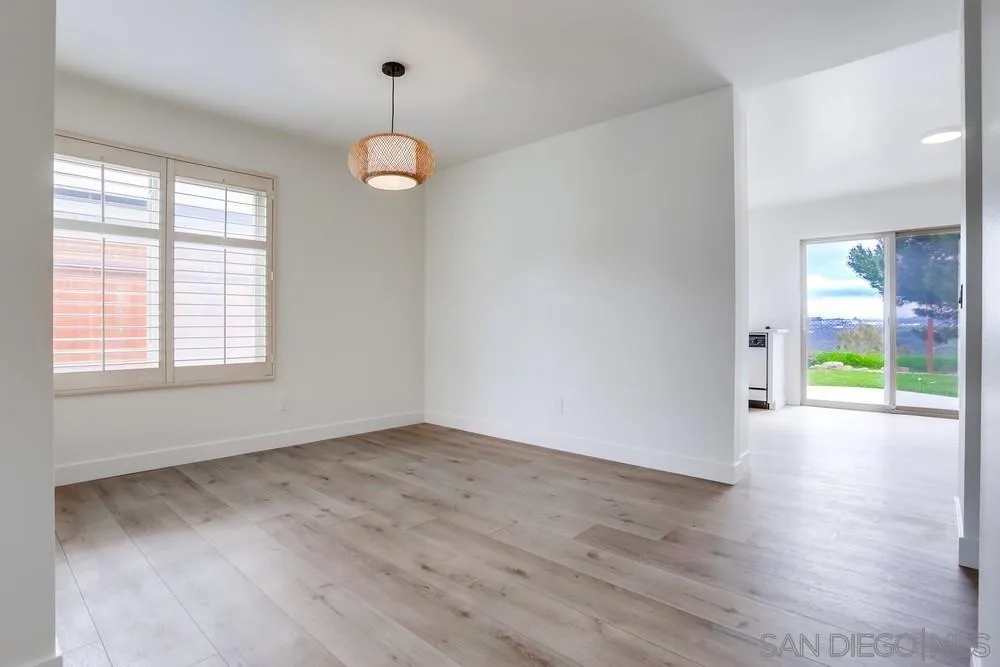384 Compass Road Oceanside, CA 92054 - Photo 9 of 34 an empty room with wooden floor and windows