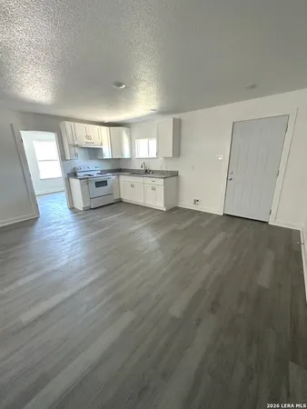 a view of a kitchen with wooden floor and electronic appliances