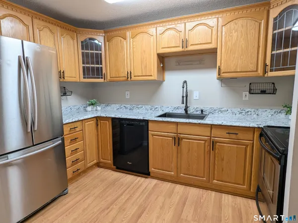 a kitchen with stainless steel appliances granite countertop a refrigerator sink and cabinets