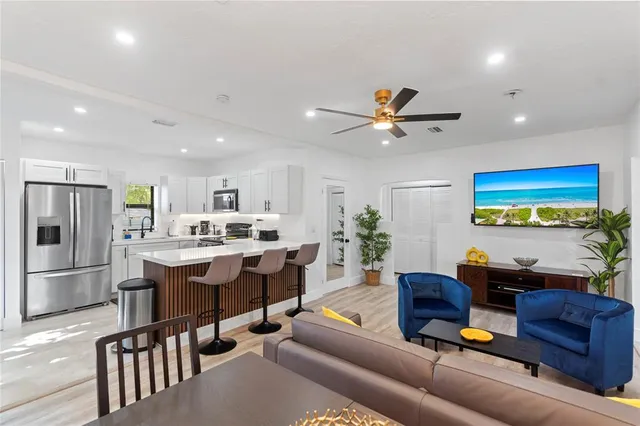 a living room with furniture kitchen view and a chandelier