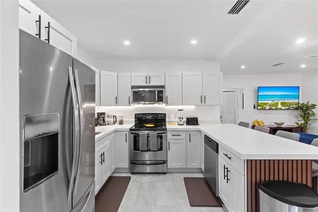 a kitchen with a sink a refrigerator and cabinets