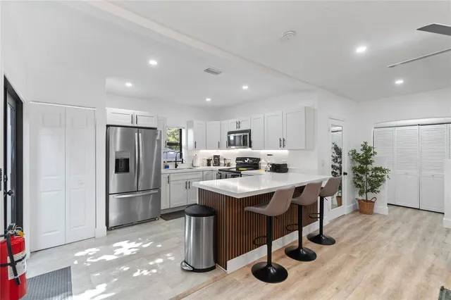 a kitchen with stainless steel appliances kitchen island hardwood floor and center island