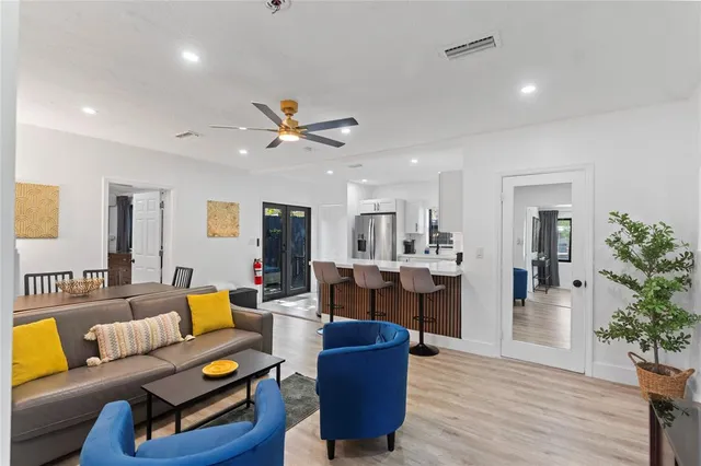 a living room with furniture kitchen view and a potted plant