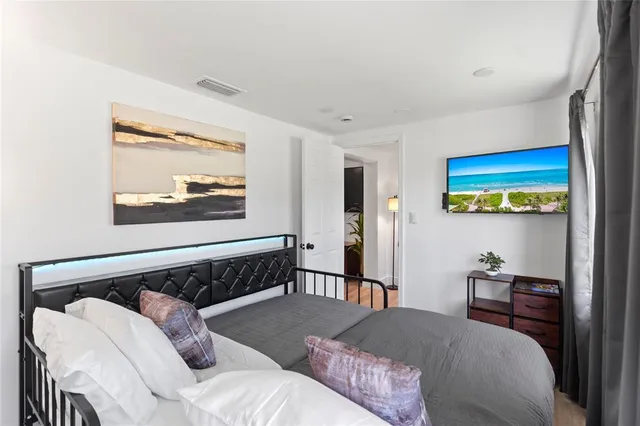 a bedroom with a bed and wooden floor