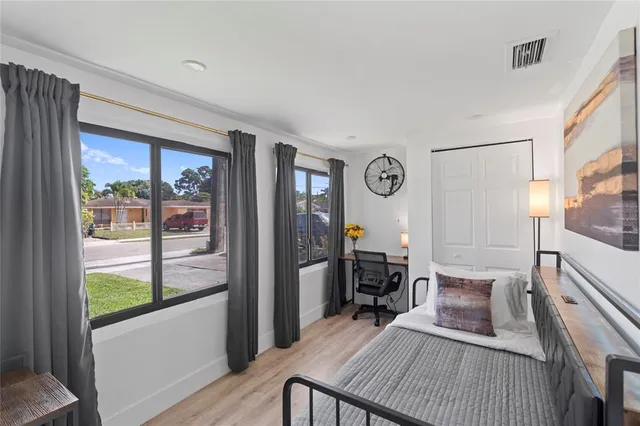 a bedroom with a bed and wooden floor