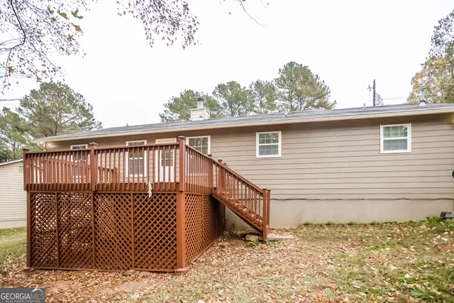 a view of a small house with wooden fence