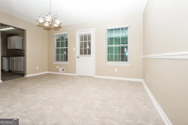 an empty room with windows and entrance