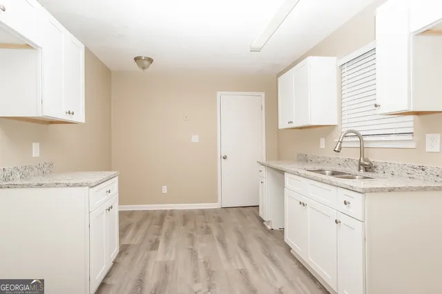 a kitchen with granite countertop a sink stove and cabinets