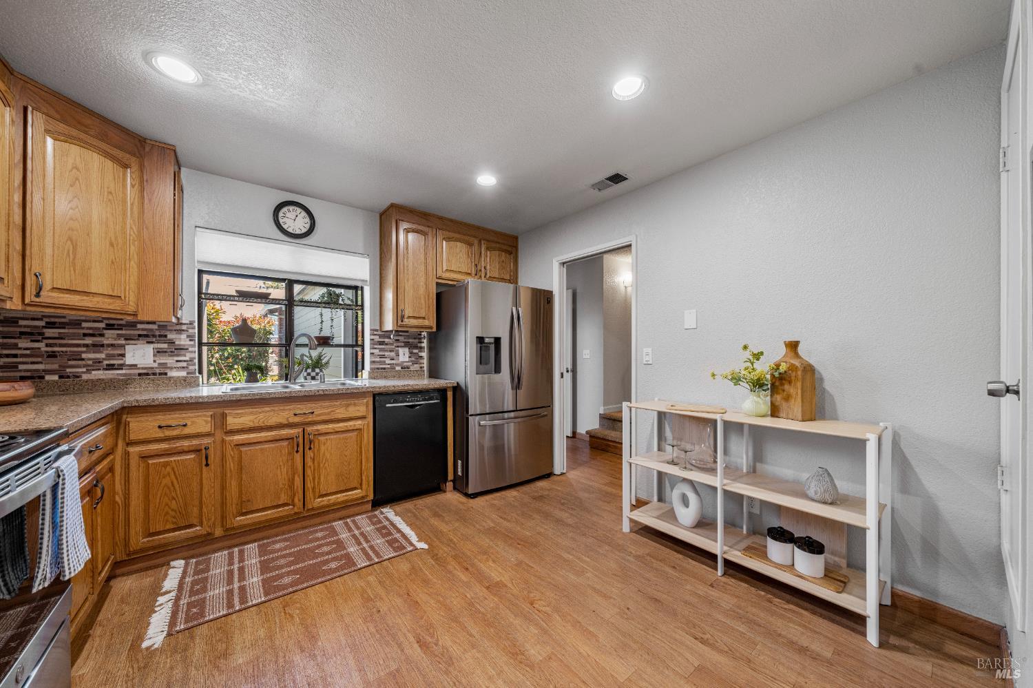 1740 Stuart Court Benicia, CA 94510 - Photo 11 of 38 a kitchen with stainless steel appliances granite countertop a refrigerator a stove a sink dishwasher and a stove with wooden floor
