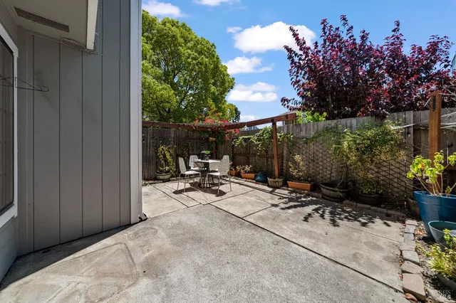 a view of a patio with table and chairs with wooden floor and fence