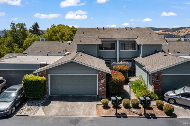 an aerial view of a house with a garden and lake view