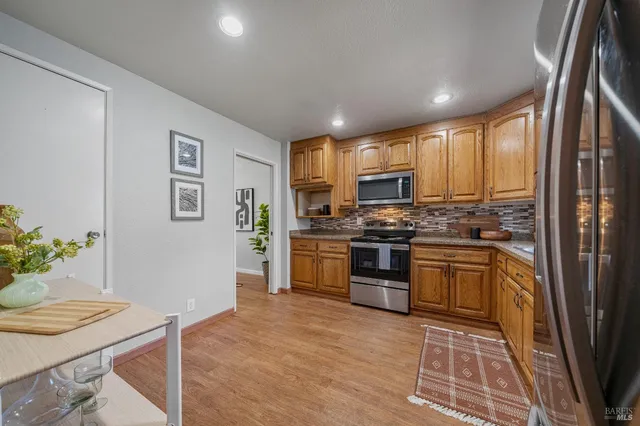 a kitchen with granite countertop stainless steel appliances and wooden cabinets